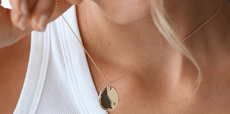 Close-up of a person wearing a delicate chain necklace with star charms.